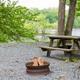 Gravel campsite with picnic table and fire ring on the riverbank — clear photo of an on-site campsite at K-Camp (source page: campground page).