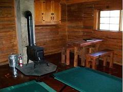 A stove and other furniture inside a wooden cabin