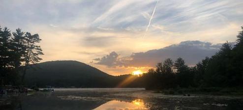 Lakeside sunset over a small dock and shoreline — matches multiple ‘Activities’/homepage images on the site depicting Forest Lake views and evening scenery.