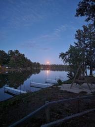 Evening/moonrise over calm lake with multiple docks visible — good scenic overview of the resort shoreline and dock layout (used on homepage).
