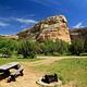 A picnic table at a campsite in Echo Park Campground with Rock Formations in the background