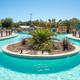 Ground-level view of the lazy river and central pool area — useful for gallery to show water amenity scale and design. Sourced from the property’s site and matches the resort’s waterpark features.