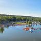 Wide aerial panorama showing the campground shoreline, docks, inflatable aqua park and RV area — strong overview of property layout (used on homepage/as hero image).