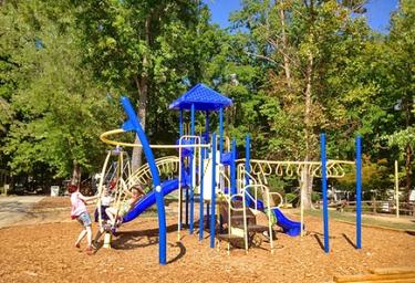 Children's playground on wooded grounds — demonstrates family-friendly onsite amenities featured on the resort page.