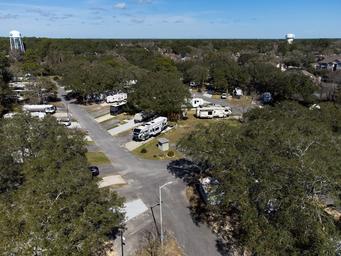 Wide drone perspective of campsites and surrounding tree canopy — another clear overview from the property's gallery page.