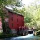 Bright red Alley Mill under the summer sun and shade trees