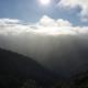 View of mountains, clouds, sun.