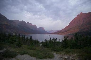 A scenic view of a lake surrounded by rocky peaks