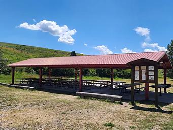 Many picnic benches under a pavilion 