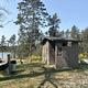 A photo of a vault toilet and trash receptacle at Wagner Lake (MI)