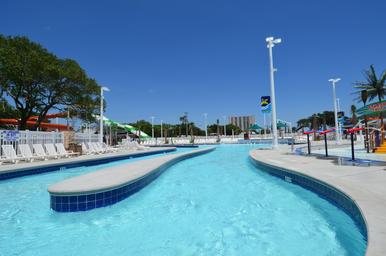 Ground-level view of the water park’s lazy river and play features, showing slides, pools and deck seating — useful detail of a major on-site amenity. Page context labels this as Sandy Harbor Water Park.