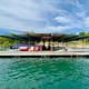 Dock on a lake with a covered seating area; water and trees in the background.