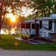 RV parked lakeside at sunset showing an RV site, firepit area and lake — useful overview of RV pitches and waterside setting (matches RVing/gallery content).