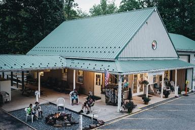 Campground office/building with front porch seating and a fire pit area — shows on‑site facilities and social space (site gallery image).