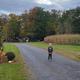 Gravel entrance drive framed with seasonal decorations and a person — clear site entry view that matches Welcome page imagery of the campground approach.