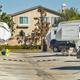 Ground-level view down an interior lane of the park showing multiple RV pitches, hookups and adjacent residences — useful for illustrating typical site spacing and park interior (matches homepage slider context).