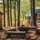 Exterior shot of a raised geodesic dome with a private firepit and rustic outhouse — clear image of the glamping accommodations on the property (source dome gallery/About page).