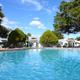 Large sparkling pool with lounge chairs and RVs visible in the background — clearly shows the on-site pool amenity referenced on the site.