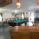 Interior clubhouse common room with pool table and seating — facility photo from the gallery that demonstrates on-site amenities and gathering space.