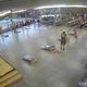 Wide indoor pavilion/recreation area showing cornhole boards, picnic tables and visitors — good for illustrating covered activity/amenity space seen on the campground site page (timestamp and WYZE overlay indicate on‑site camera/promo image).