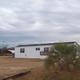 Exterior shot of a mobile home on open grounds with nearby amenities visible and natural sky — provides another angle of on-site housing and site layout (source: Rentals wrapper, rentimages/5.jpg).