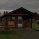 Cabin exterior photo showing a wooden rental cabin with porch and picnic table — represents the campground's cabin lodging. Labeled under Cabins on the site.