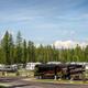 Wide view of multiple RV sites with trees and mountain backdrop, clearly depicting the park’s RV pitch style and setting from the site gallery.