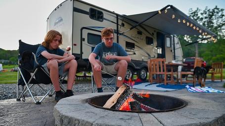 Evening campsite scene with RV, seating and a fire ring where guests roast marshmallows—depicts typical RV/campsite experience at the KOA (from the campground's ways-to-stay photos).