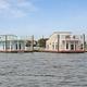 Two waterfront houseboats/floating homes viewed from the water — good overview of the marina-facing rental units and shoreline context; appears in the site photo gallery (image-2-new-1.jpg).