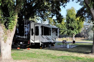 Close view of an RV site with patio area and river-facing grassy setting — high-quality gallery image illustrating individual campsite layout and waterfront proximity (gallery page).