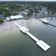 Aerial/drone view showing the waterfront, long pier with covered pavilions and adjacent campground buildings — ideal overall site overview (sourced from the property’s gallery page).