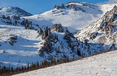 Rocky outcrops protrude from snow-covered mountains