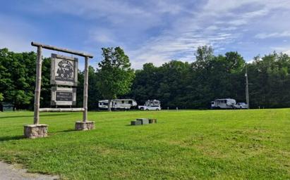 Entrance sign and open field with several RVs visible — shows campground layout and entry area. Image appears on the site’s main pages (https://tildenhillfarm.com/). Useful for property identification.