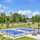 Photo of the pickleball courts and adjacent green space within the community — matches amenities listed on the Resort Amenities page and shows recreational facilities.