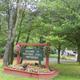 Welcome sign at the entrance with landscaping and campground roadway — clear property identifier and entrance view used on the site.