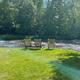 Riverside seating area with three chairs on the riverbank — highlights waterfront scenery and guest relaxation spots (gallery image G8).