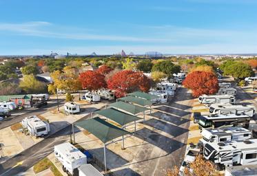 Aerial shot of the resort highlighting covered RV pads, tree-lined rows and nearby attractions in the distance — useful detailed overview and matches the site’s gallery imagery.
