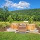 Outdoor soaking tubs (two wooden tubs) set in landscaped grounds with forested hill backdrop — shows on-site amenities and scenic setting (image appears in the site's facilities/gallery).