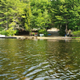 Wide waterfront panorama showing boats, dock and sandy shore — useful overview of the campground shoreline and boat access (background/header image on the site).
