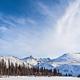 A frozen river and mountains under a blue sky