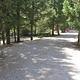 Gravel road in forest with person walking in background