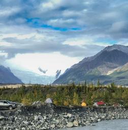 Campsite scene with tents, vehicles and glacier in background — illustrates tent camping and views from the campground (source photos page and filename indicate camp area).