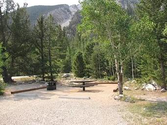 Campsite with picnic table and fire pit with mountain in background