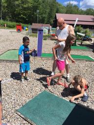 Image of the miniature golf area with children playing — shows an on-site recreational facility (used on Contact/Amenities pages) and helps convey family activities available.