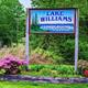 Clear full-color photo of the campground entrance sign with landscaping and roadway visible — useful as an identifying exterior shot; sourced from the site’s homepage images.