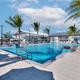 Ground-level pool photo showing pool deck, water features and clubhouse in background — useful for guests viewing recreational facilities (gallery).