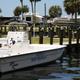 Clear waterfront shot showing a rental boat in the marina with RVs, docks and grassy park area in the background — supports marina and RV slip amenities (from the site's Boat Rentals context).