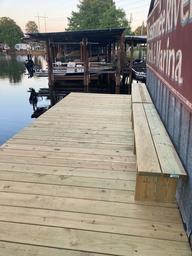 A wooden dock with a sign that says marina on it