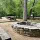 Stone fire ring surrounded by wooden benches