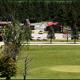 Wide grounds view showing open green space, a golf/putting area and campground structures across a road — a useful panorama of the resort’s layout. Image is from the site’s Amenities page, indicating on-property scenery.